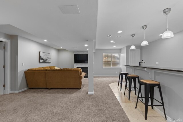 living room with visible vents, a fireplace, baseboards, recessed lighting, and light colored carpet