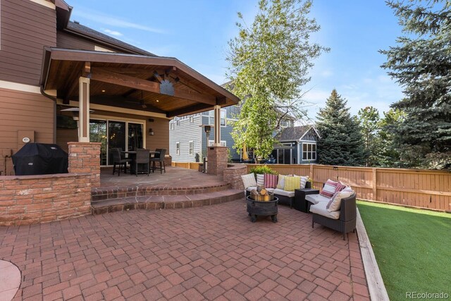 view of patio / terrace with area for grilling, a ceiling fan, fence, outdoor lounge area, and outdoor dining space