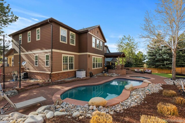 rear view of property featuring fence, a patio, a fenced in pool, central AC unit, and an in ground hot tub