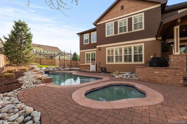 view of pool with area for grilling, a fenced backyard, a fenced in pool, an in ground hot tub, and a patio area