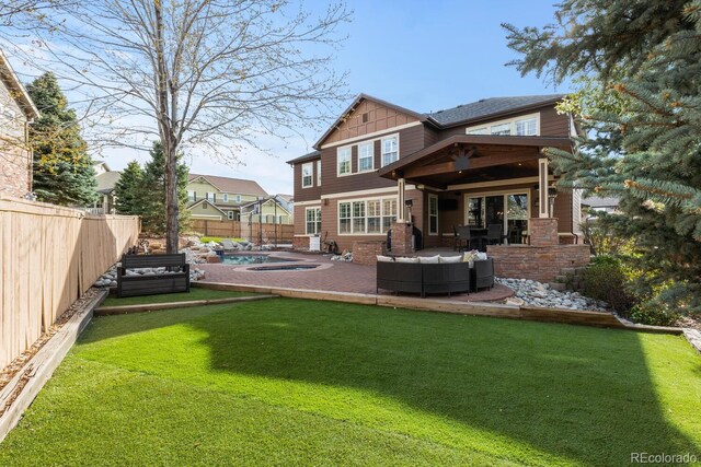 back of property featuring a jacuzzi, a fenced backyard, an outdoor living space, a patio area, and a lawn