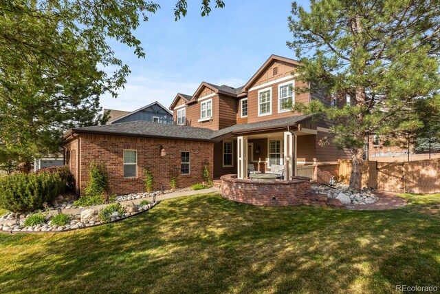 rear view of house with brick siding and a yard