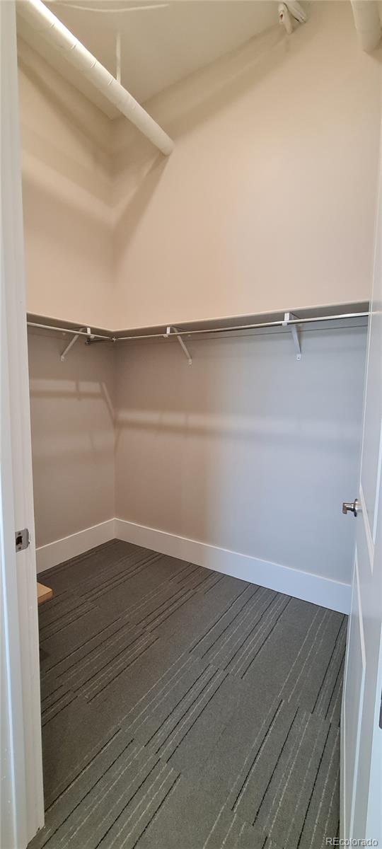 walk in closet featuring dark wood-style flooring