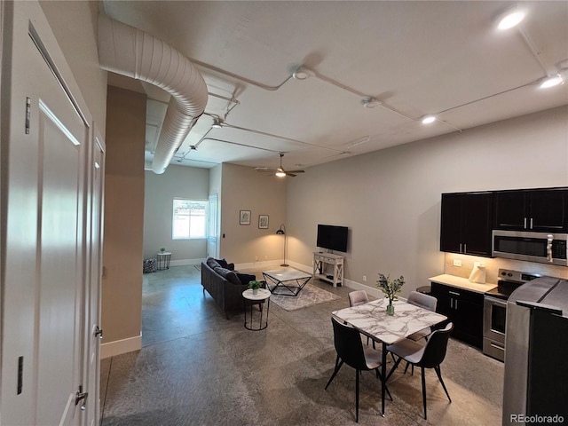 dining room featuring finished concrete floors, baseboards, and a ceiling fan