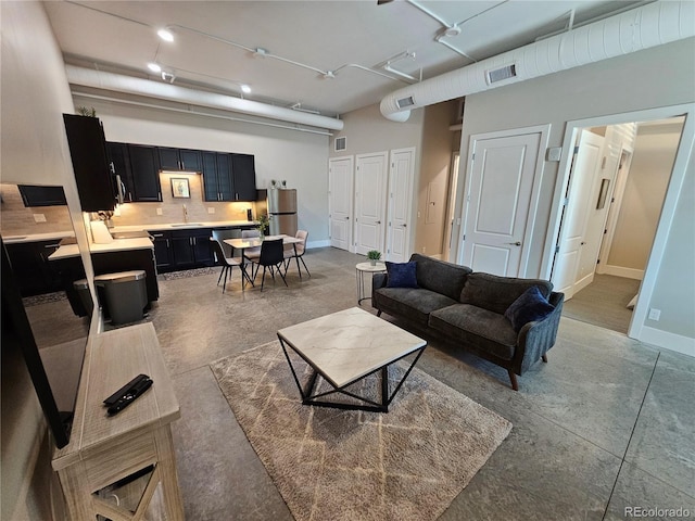 living area featuring finished concrete floors and baseboards