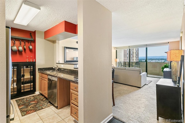 1020 15th St Unit 16A, Denver, CO 80202 - kitchen with stainless steel appliances, a textured ceiling, a sink, dark stone counters, and open floor plan