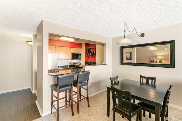 1020 15th St Unit 16A, Denver, CO 80202 - dining area with a textured ceiling, baseboards, and wood finished floors