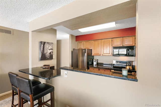 1020 15th St Unit 16A, Denver, CO 80202 - kitchen with freestanding refrigerator, black microwave, stainless steel electric range, a kitchen bar, and a peninsula