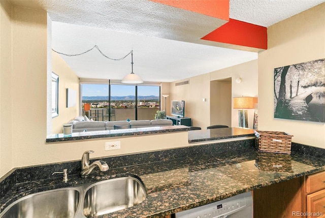 1020 15th St Unit 16A, Denver, CO 80202 - kitchen featuring a sink, dishwashing machine, a textured ceiling, open floor plan, and dark stone counters