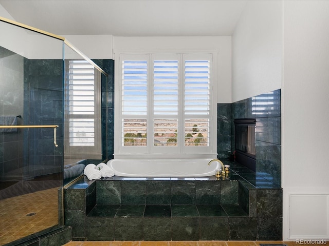 bathroom with separate shower and tub and a fireplace