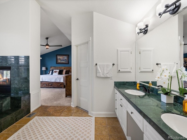 bathroom featuring ceiling fan, lofted ceiling, and vanity