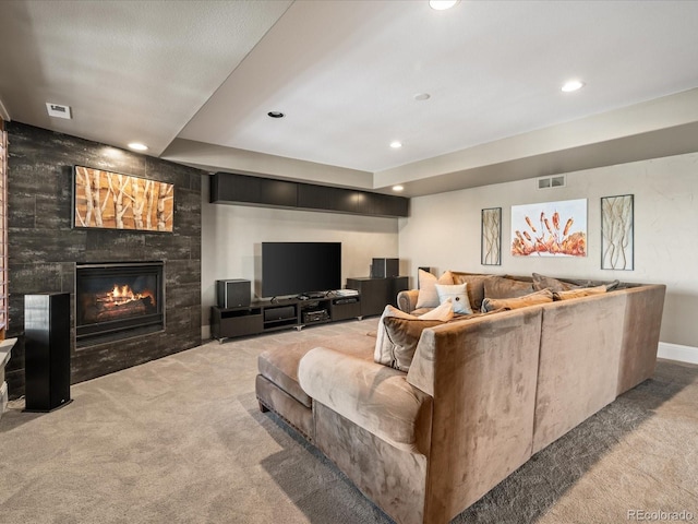 living room with a tile fireplace and carpet