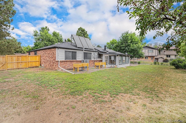 6898 S Franklin Cir, Centennial, CO 80122 - rear view of property with a sunroom, brick siding, solar panels, and a fenced backyard