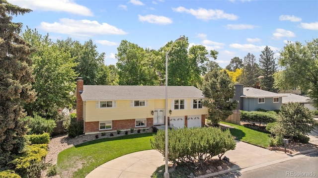 2315 N Murray Blvd, Colorado Springs, CO 80915 - split foyer home with an attached garage, a chimney, driveway, and brick siding