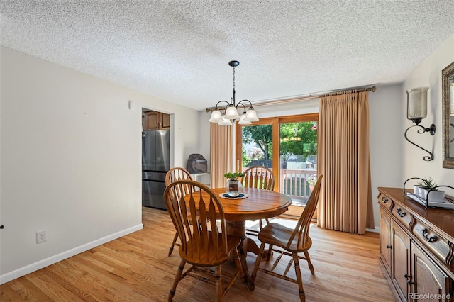 2315 N Murray Blvd, Colorado Springs, CO 80915 - dining space with light wood-style floors, a chandelier, and a textured ceiling