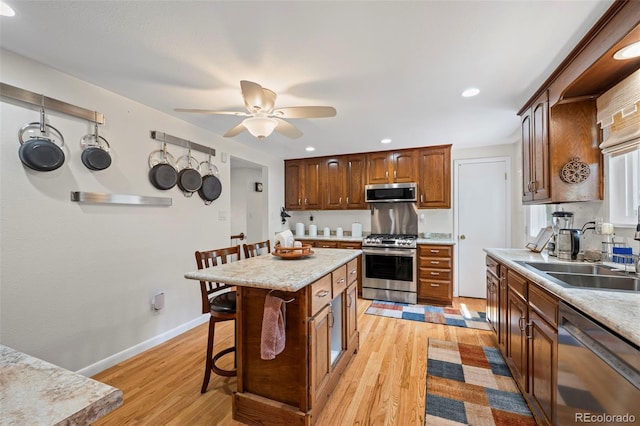 2315 N Murray Blvd, Colorado Springs, CO 80915 - kitchen featuring appliances with stainless steel finishes, a breakfast bar, light wood-style flooring, a ceiling fan, and recessed lighting