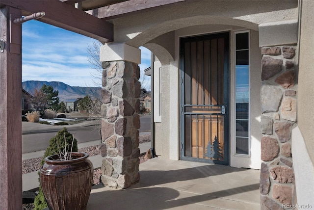 entrance to property with a mountain view and a patio