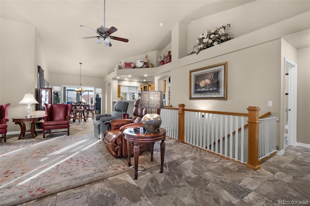 living room featuring ceiling fan with notable chandelier and high vaulted ceiling