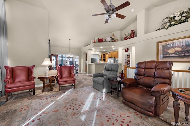 living room featuring high vaulted ceiling and ceiling fan with notable chandelier