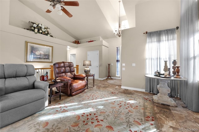 living room featuring a wealth of natural light, high vaulted ceiling, and ceiling fan with notable chandelier