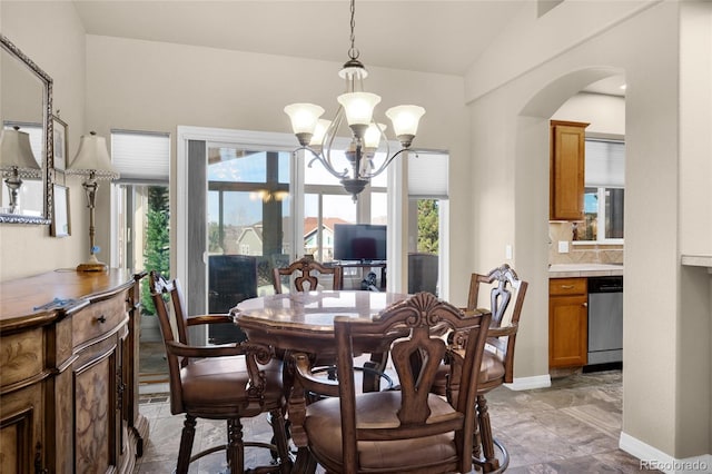 dining room with vaulted ceiling, an inviting chandelier, and a healthy amount of sunlight