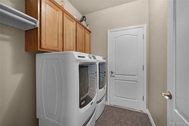 laundry area featuring separate washer and dryer and cabinets