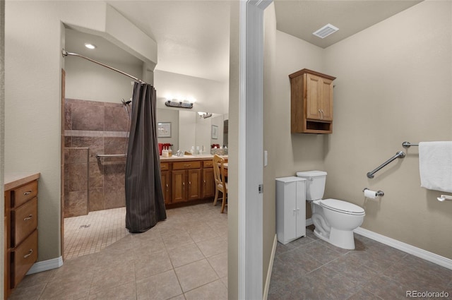 bathroom with toilet, vanity, tile patterned floors, and walk in shower