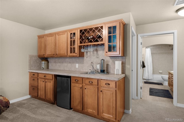 kitchen with black refrigerator, sink, and light carpet