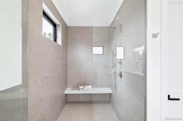 bathroom featuring tile walls, tiled shower, and tile patterned flooring