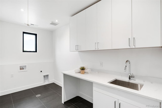 laundry area featuring hookup for a washing machine, dark tile patterned flooring, hookup for an electric dryer, sink, and cabinets