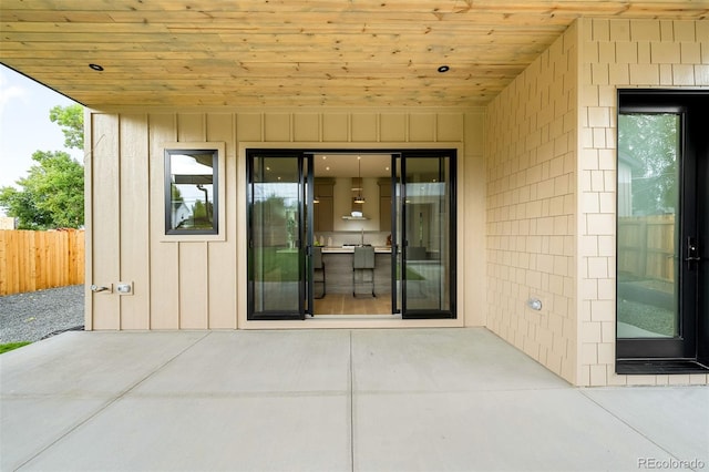 view of exterior entry with a patio area