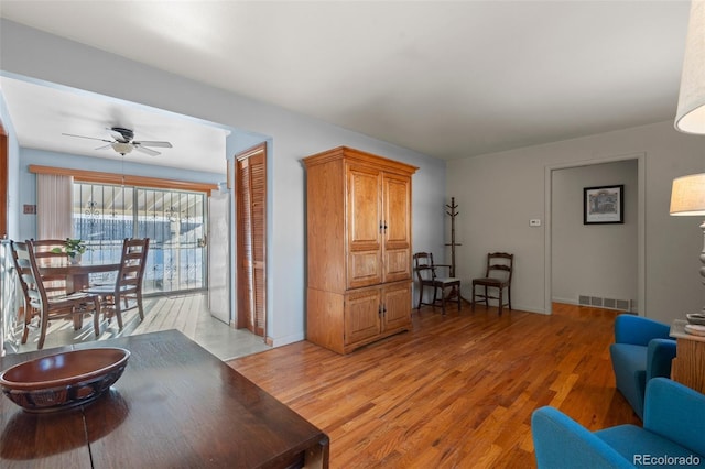 living room featuring ceiling fan and light hardwood / wood-style flooring