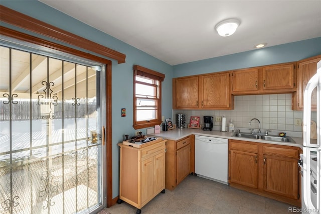 kitchen featuring stainless steel stove, dishwasher, sink, and tasteful backsplash