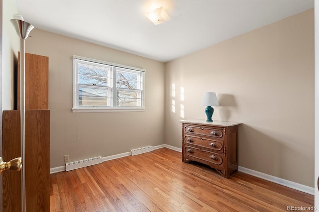 bedroom featuring a baseboard radiator and light hardwood / wood-style flooring