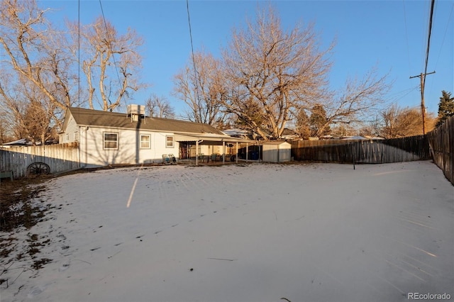 view of snow covered rear of property