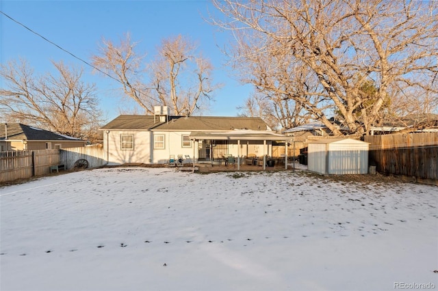 view of snow covered back of property