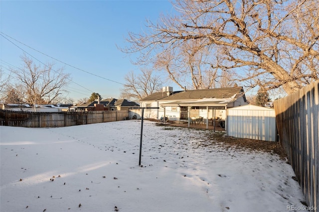 snowy yard with a storage unit