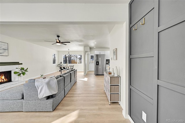 living room with ceiling fan and light hardwood / wood-style flooring