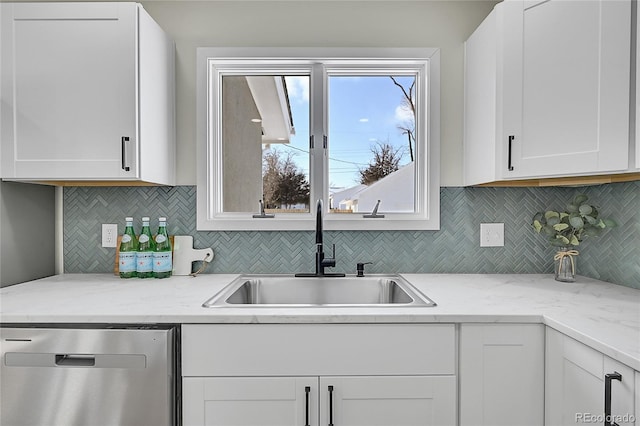 kitchen with white cabinetry, decorative backsplash, sink, light stone counters, and stainless steel dishwasher