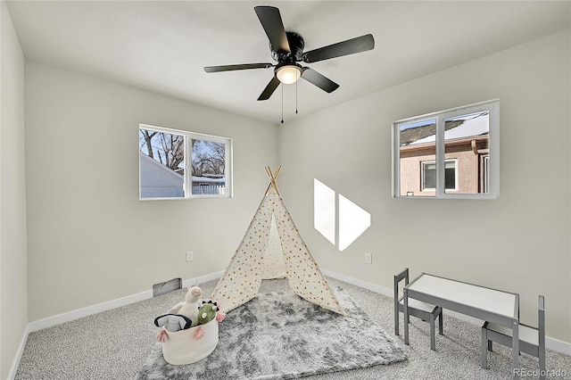 playroom featuring ceiling fan, carpet flooring, and a healthy amount of sunlight