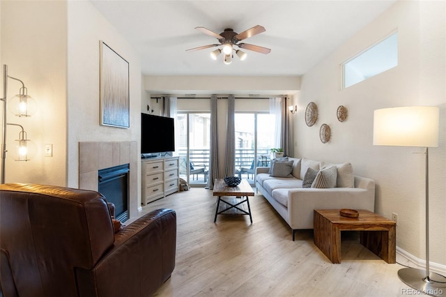 1816 Montura Vw Unit 204, Colorado Springs, CO 80919 - living area featuring light wood-type flooring, a ceiling fan, a tile fireplace, and baseboards