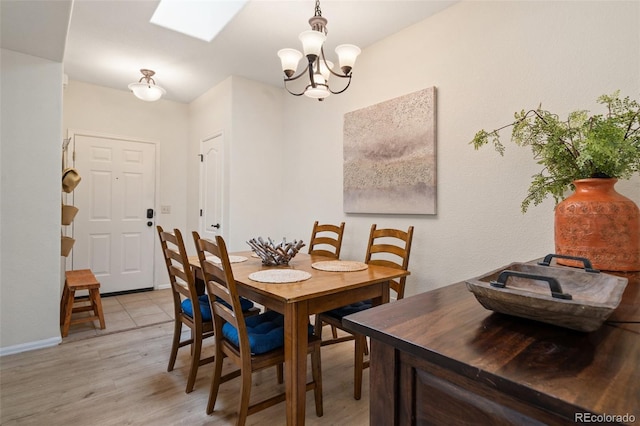 1816 Montura Vw Unit 204, Colorado Springs, CO 80919 - dining area with baseboards, light wood finished floors, an inviting chandelier, and a skylight