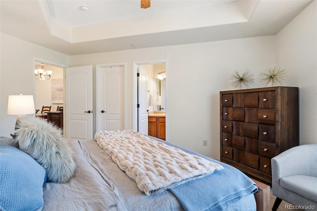 1816 Montura Vw Unit 204, Colorado Springs, CO 80919 - bedroom featuring ensuite bath, a notable chandelier, and a raised ceiling