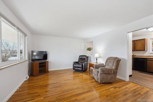 living area with visible vents, baseboards, and light wood finished floors