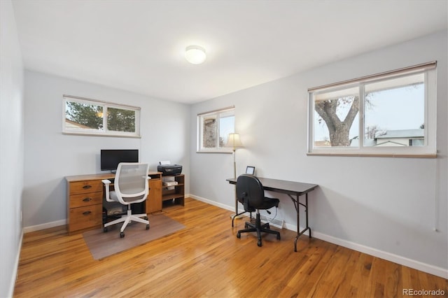 office area with light wood finished floors, baseboards, and a wealth of natural light