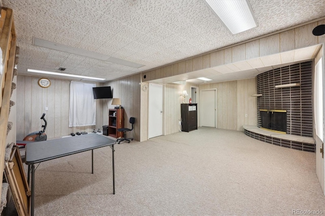 recreation room with carpet floors and a brick fireplace