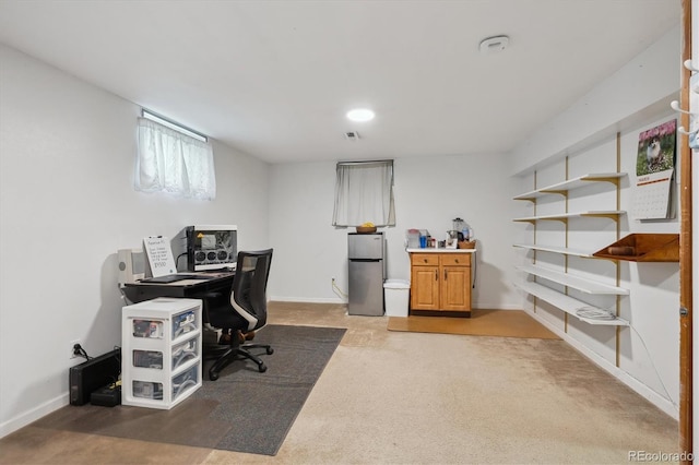 carpeted office space featuring visible vents and baseboards