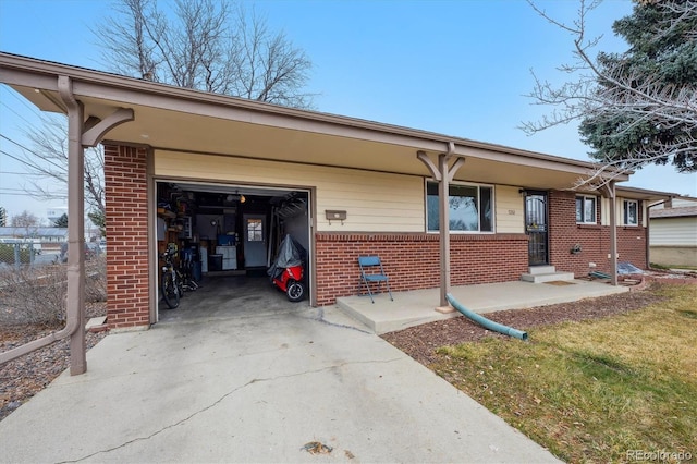 view of front of home with a garage, brick siding, and concrete driveway