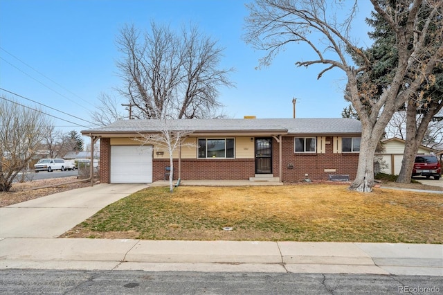 view of front of house with a garage, a front yard, concrete driveway, and brick siding