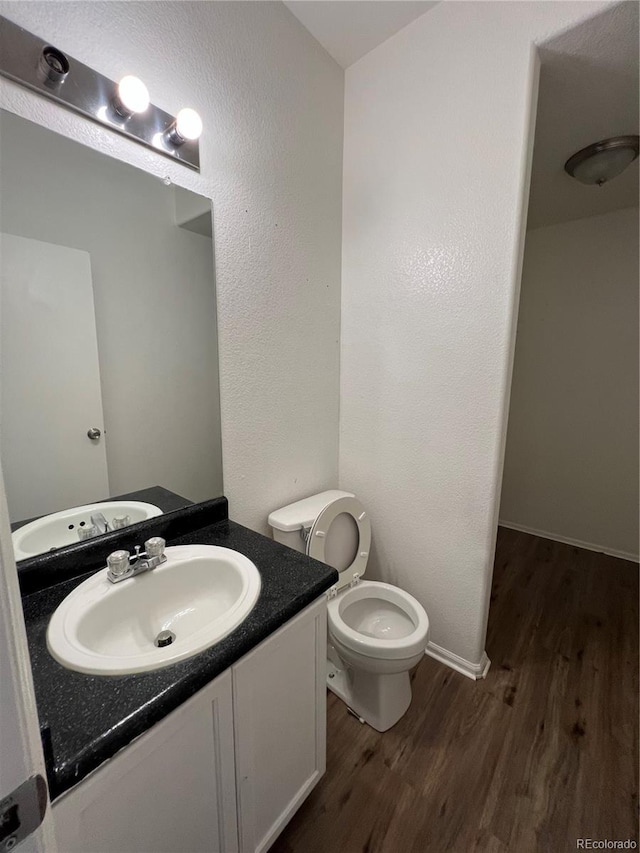 bathroom featuring vanity, toilet, and wood-type flooring